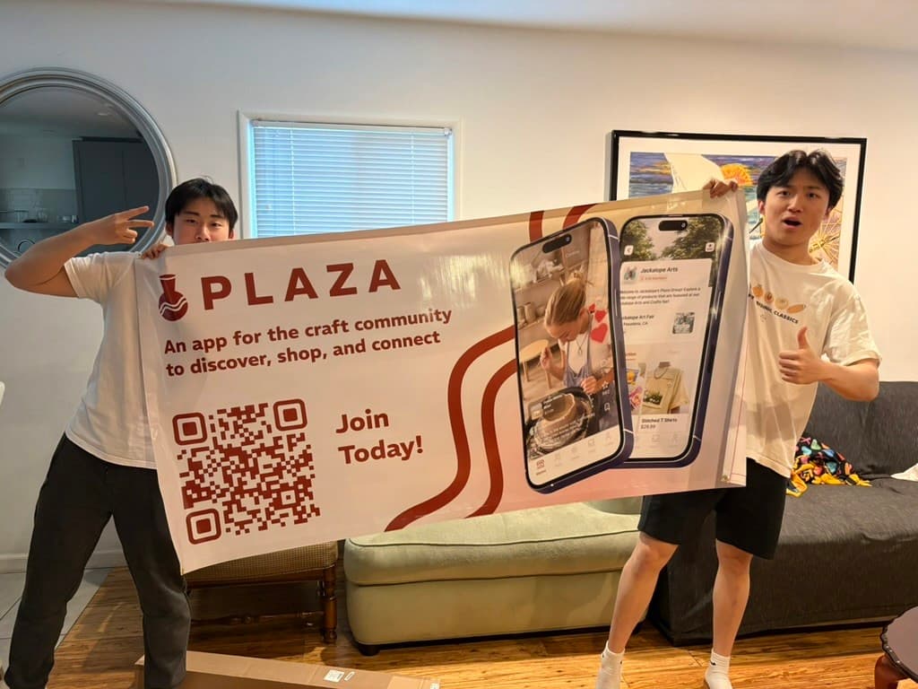 The team holding up a Plaza banner with a QR code to join