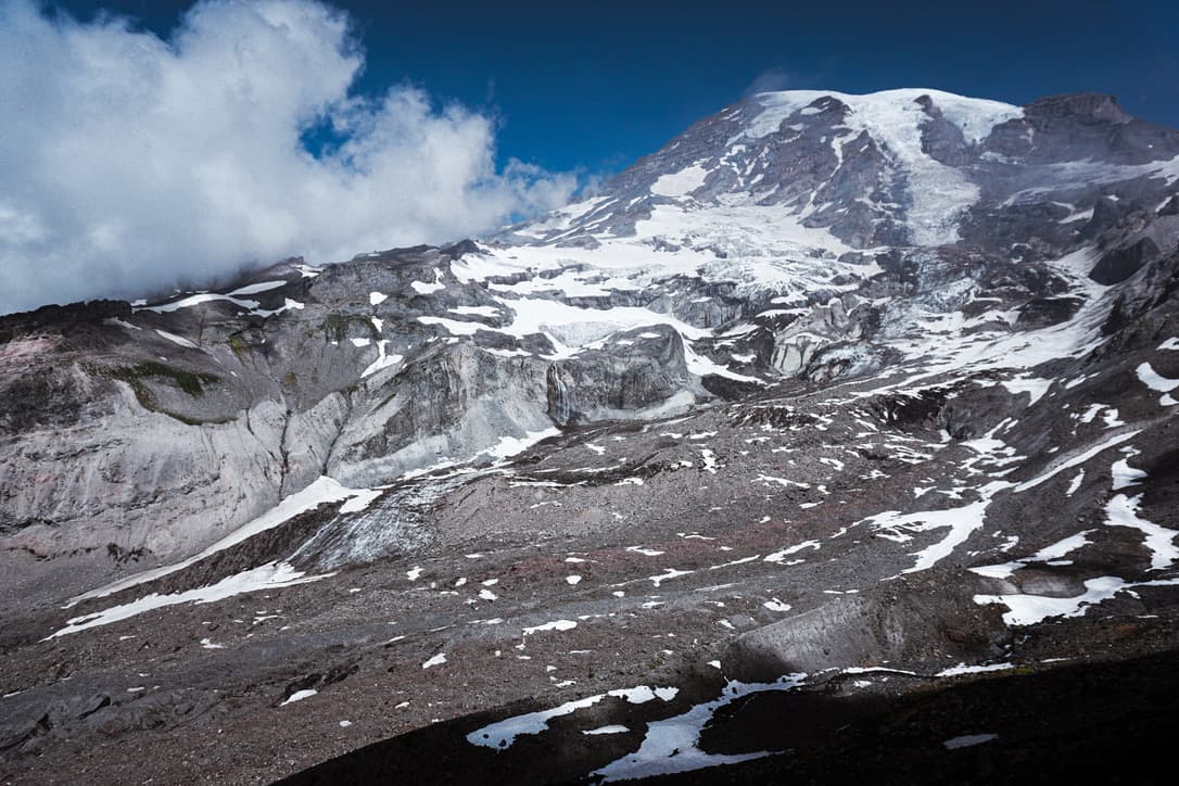 A snow-covered volcanic peak under a blue sky