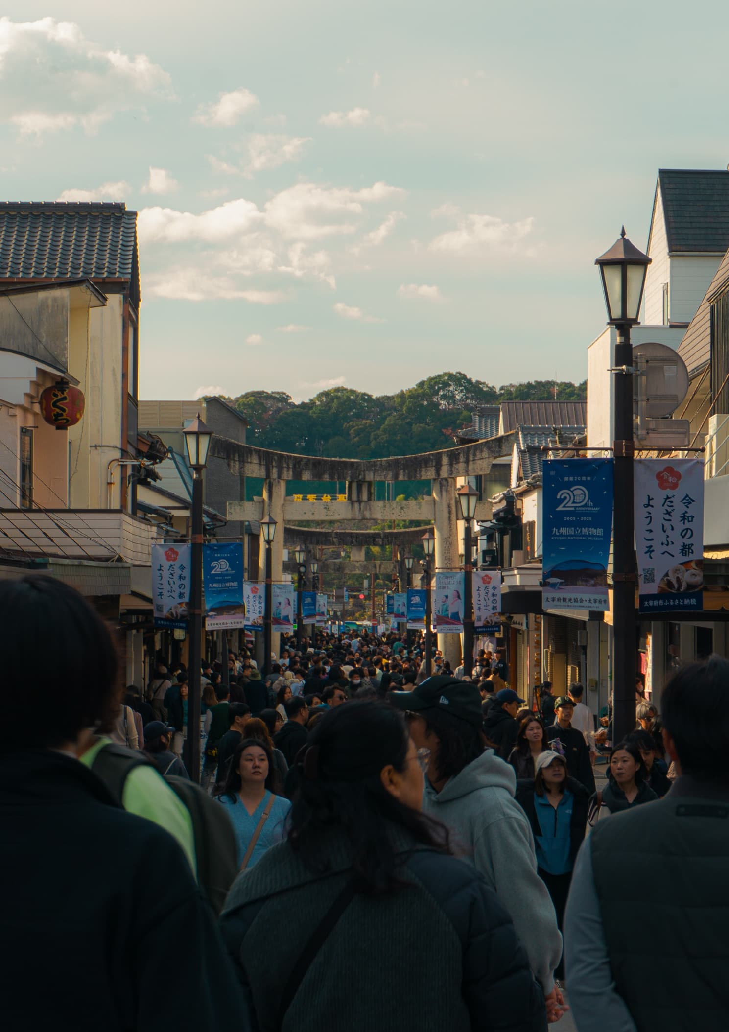 A busy shopping street with a gate and hanging banners