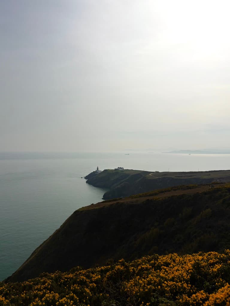 A coastal headland silhouetted against a hazy sky